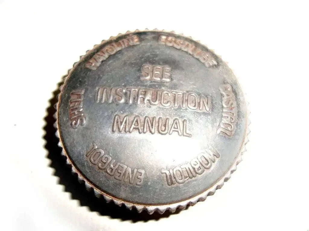 Round metal oil tank filler cap with embossed Instruction Manual text