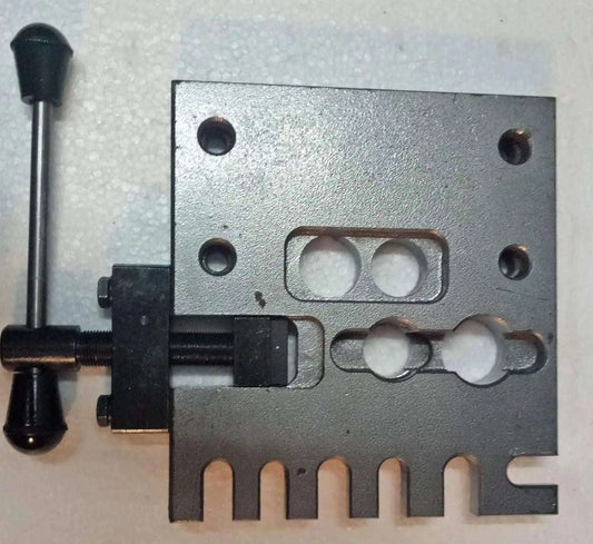 Gray metal holding plate fixture with bolt holes and central cutout
