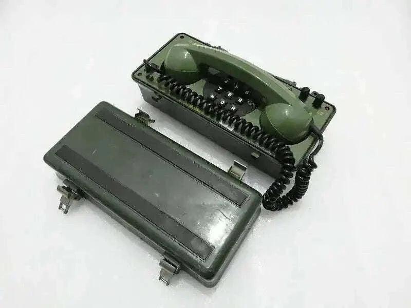 Military green field telephone with handset and keypad, angled view