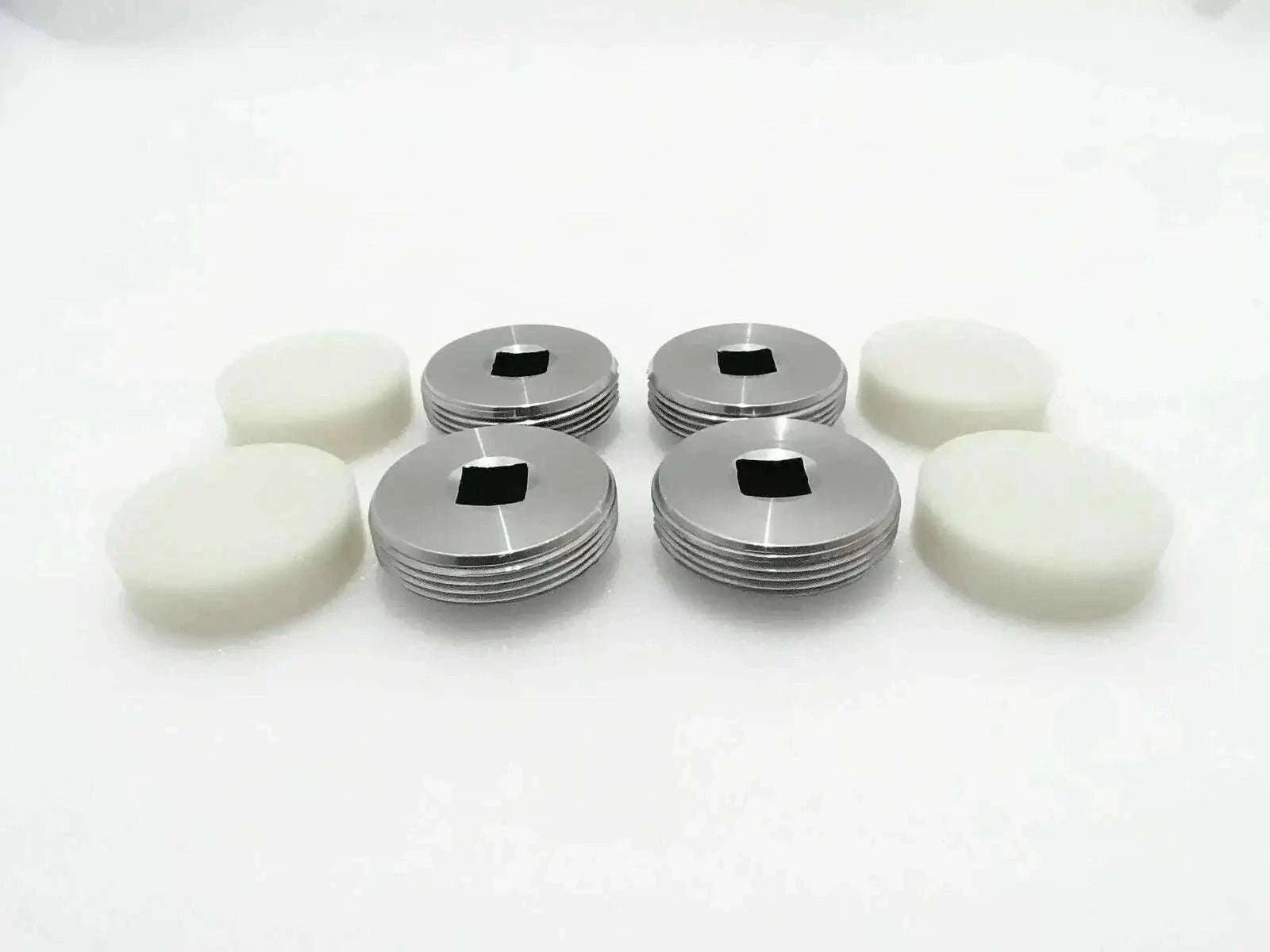 Set of 4 wear pads with white bases and silver metal caps.